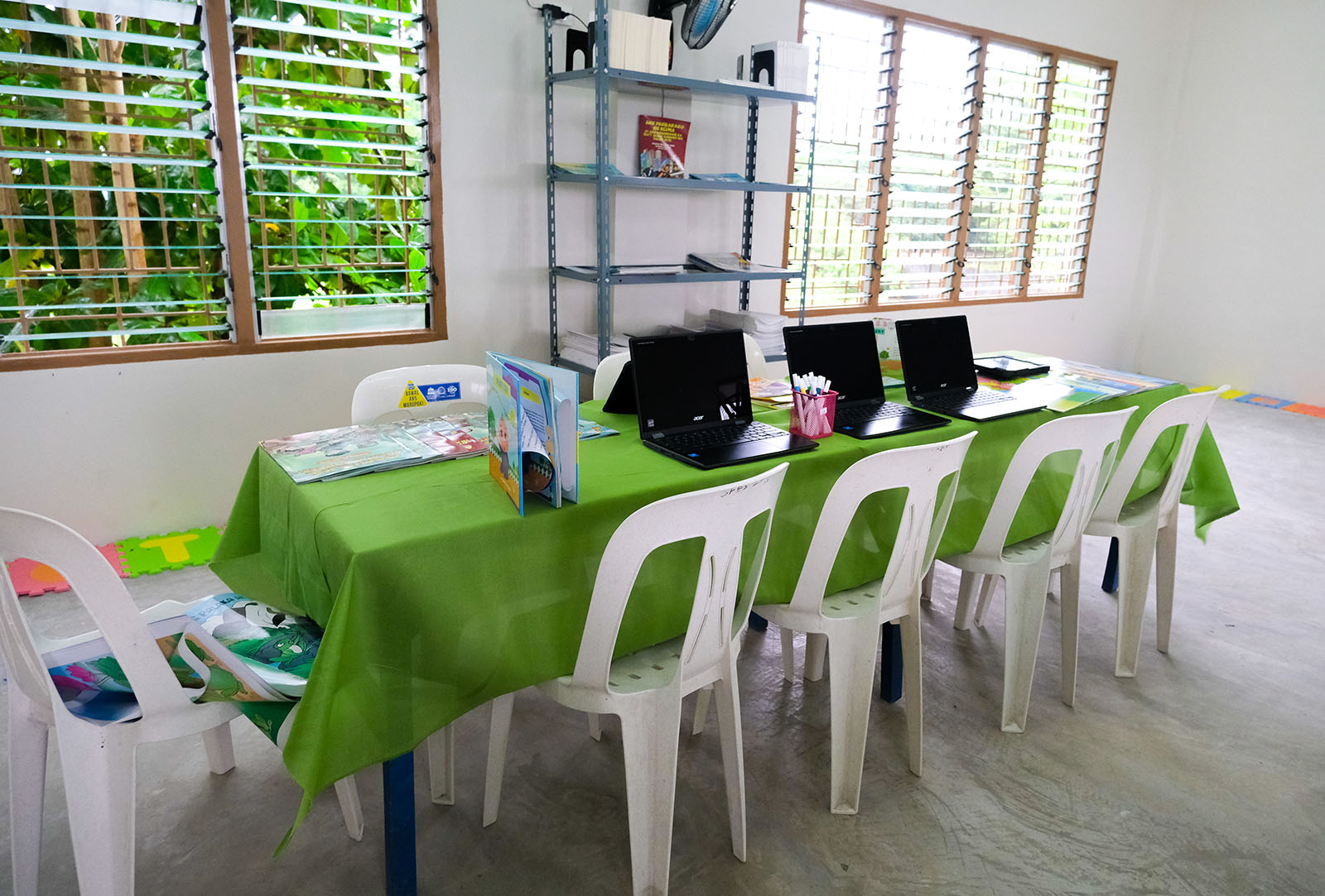 Laptops and children's books set out on a table in the new library